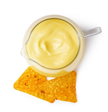 Bir sürahi lezzetli çedar peyniri sosu ve beyaz arka planda nacho.