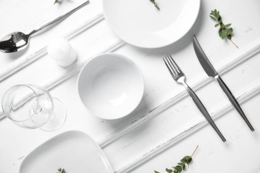 Beyaz ahşap zemin üzerinde şık masa ayarları ve mum