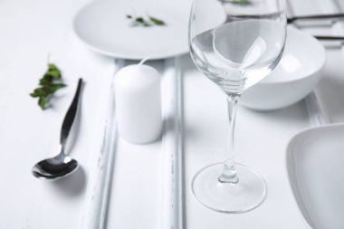 Beyaz ahşap zemin üzerinde şık masa ayarları ve mum