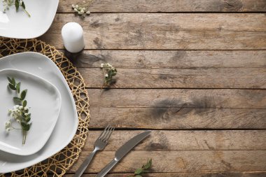 Zarif masa ayarı ve kahverengi ahşap arka planda mumu olan hasır bir hasır.