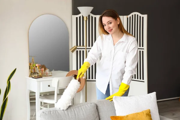 Młoda Kobieta Sprzątanie Sofa Duster Domu — Zdjęcie stockowe