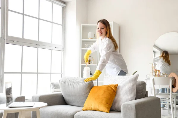 Junge Frau Putzt Sofa Hause Mit Staubwedel — Stockfoto