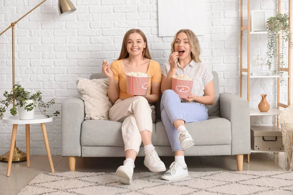 Young Sisters Eating Popcorn Sofa Home — Stock Photo, Image