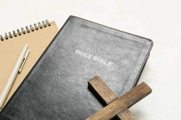 圣经上有木制十字架和白色背景的笔记本 — 图库照片