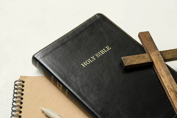 圣经上有木制十字架和白色背景的笔记本 — 图库照片
