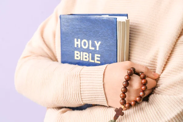Kobieta Trzymająca Biblię Liliowym Tle — Zdjęcie stockowe