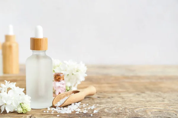 Flessen Cosmetische Olie Met Mooie Lila Bloemen Zeezout Houten Tafel — Stockfoto