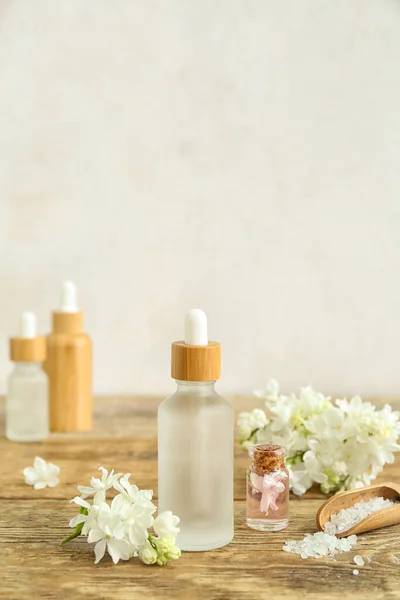 Flessen Cosmetische Olie Met Mooie Lila Bloemen Zeezout Houten Tafel — Stockfoto
