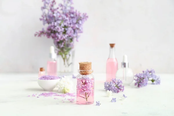 Bottles Cosmetic Oil Beautiful Lilac Flowers Sea Salt White Table — Stock Photo, Image