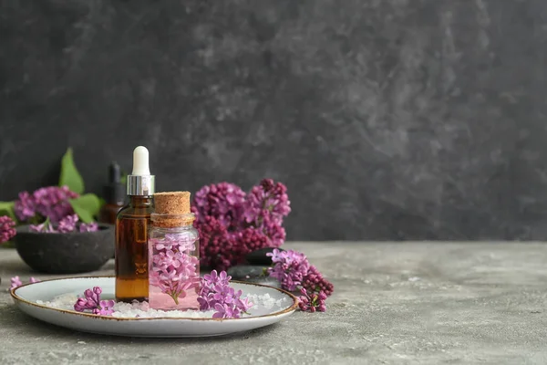 Flessen Cosmetische Olie Met Mooie Lila Bloemen Zeezout Grijze Tafel — Stockfoto