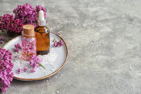 Flessen Cosmetische Olie Met Mooie Lila Bloemen Zeezout Grijze Tafel — Stockfoto