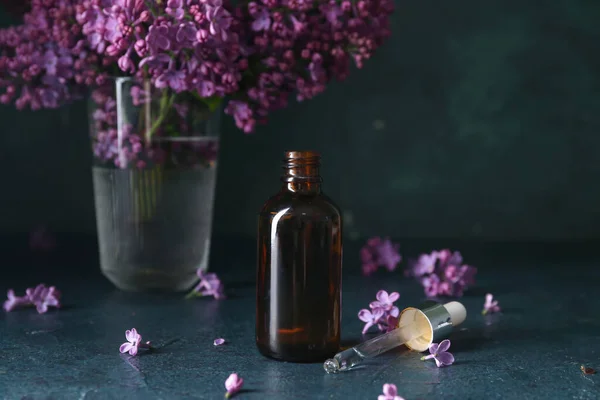 Bottle Cosmetic Oil Beautiful Lilac Flowers Dark Table — Stock Photo, Image