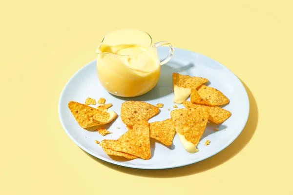 底色淡黄的盘子里 盛满了可口的切达芝士酱和玉米片 — 图库照片