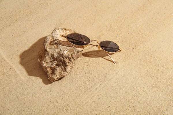 Pietra Con Eleganti Occhiali Sole Sulla Sabbia — Foto Stock