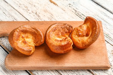 Hafif ahşap zemin üzerinde lezzetli Yorkshire pudingi olan tahta.