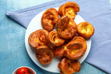 Mavi arka planda lezzetli Yorkshire pudingi olan tahta