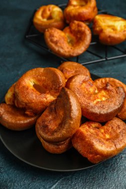 Mavi arka planda lezzetli Yorkshire pudingi olan tabak.