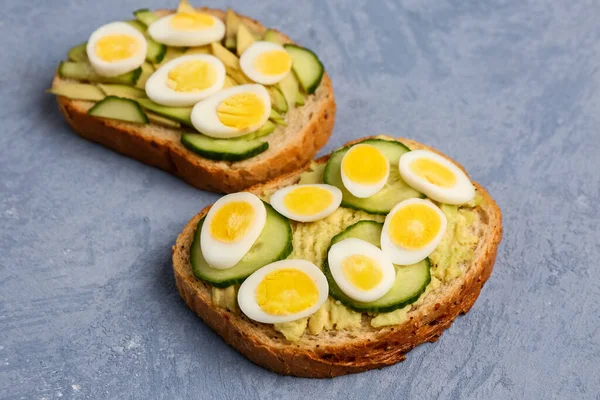 Tasty Toasts Quail Eggs Avocado Cucumber Blue Background Closeup — Stock Photo, Image