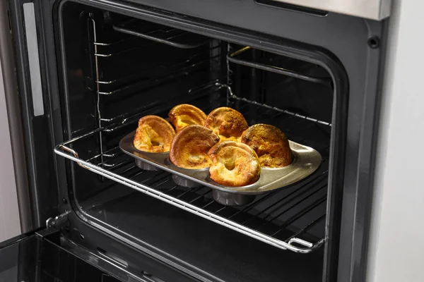 Baking tin with tasty Yorkshire pudding in oven
