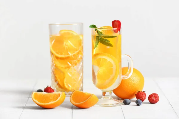 白色瓷砖底注入橙片水的玻璃杯 — 图库照片