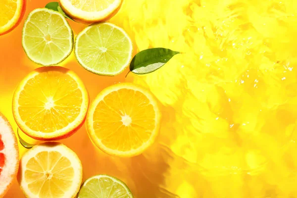 Diferentes Fatias Frutas Cítricas Folhas Água Fundo Amarelo — Fotografia de Stock