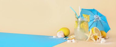 Bir bardak taze limonata, şemsiye, limon, şeker ve deniz kabuğu bej arka planda metin için yer var.
