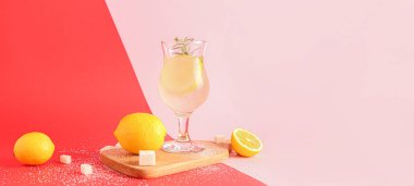 Renkli arka planda bir bardak taze limonata, şeker ve limon.