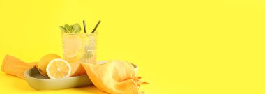 Sarı zemin üzerinde bir bardak taze limonata ve metin için yer var.