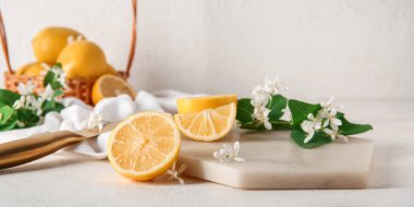 Beyaz masanın üzerinde açan dalları olan taze limonlar.