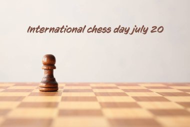 Hafif arka planda satranç taşı olan tahta. Uluslararası Satranç Günü