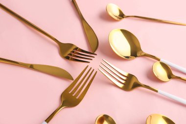 Pembe arka planda şık çatal bıçak takımı