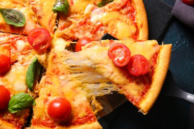 Koyu arkaplanda lezzetli pizza margaritası olan pano.