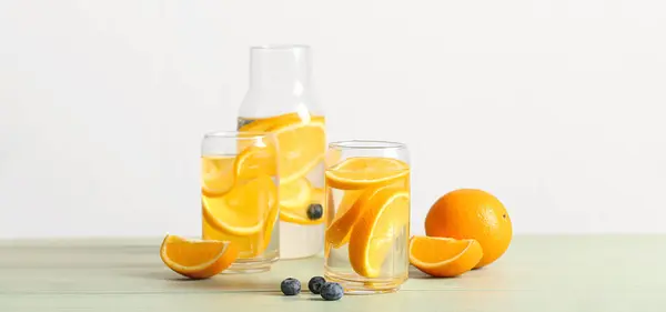 テーブルの上にオレンジの注入水のグラスとボトル — ストック写真