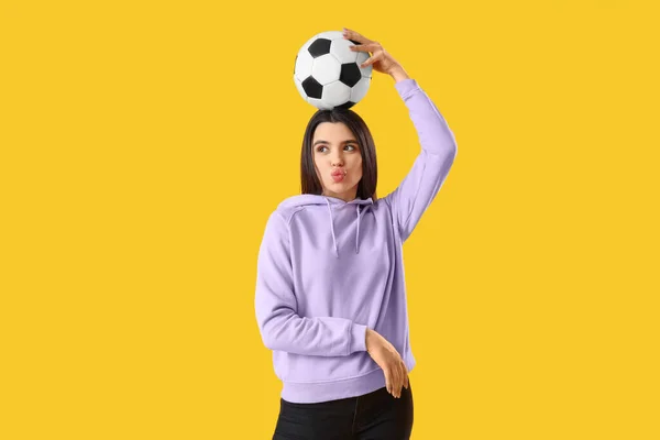 Όμορφη Νεαρή Γυναίκα Μπάλα Ποδοσφαίρου Κίτρινο Φόντο — Φωτογραφία Αρχείου