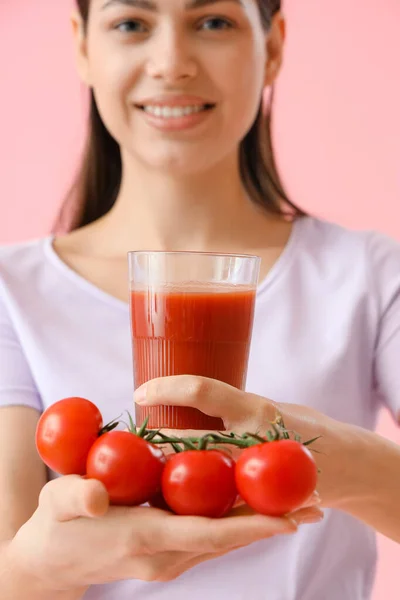 ピンクの背景に野菜ジュースとトマトのガラスを持つ若い女性 クローズアップ — ストック写真
