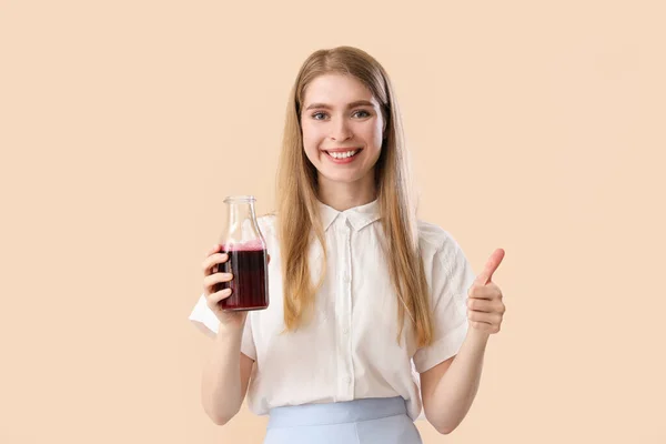 Young Woman Bottle Beet Juice Pointing Something Beige Background — Stock Photo, Image