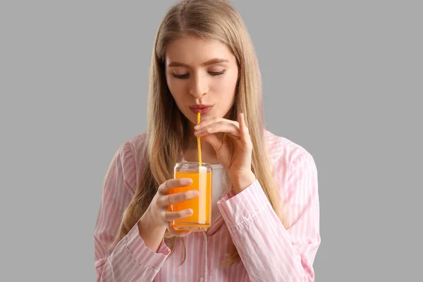 Młoda Kobieta Pije Sok Warzywny Szarym Tle Zbliżenie — Zdjęcie stockowe