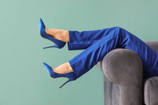 女性足で高いですかかとでソファに青の背景 — ストック写真