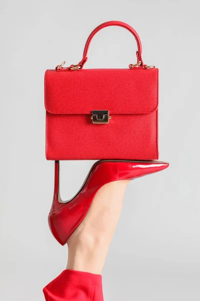 女性の足で赤高いですヒールとともにバッグ上灰色の背景 — ストック写真