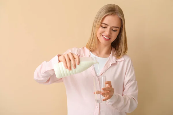 Beautiful Young Woman Pouring Milk Glass Beige Background — Stock Photo, Image