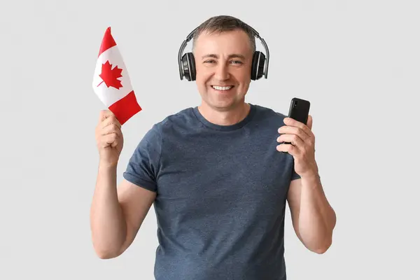 Uomo Maturo Cuffia Con Bandiera Del Canada Telefono Cellulare Sfondo — Foto Stock