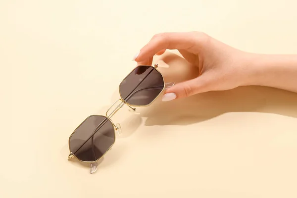 Female Hand Holding Stylish Sunglasses Beige Background — Stock Photo, Image