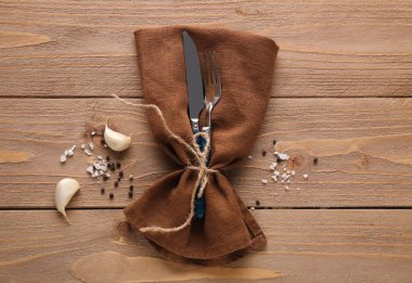 Peçete çatallı gümüş bıçak ve ahşap arka planda biber.