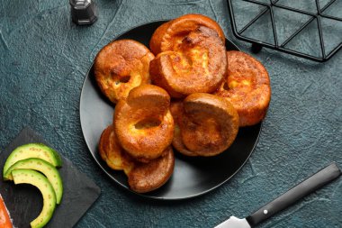 Mavi arka planda lezzetli Yorkshire pudingi olan tabak.