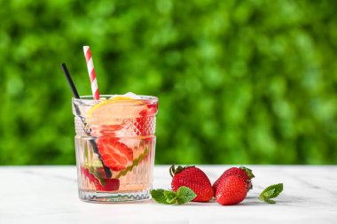 Dışarıdaki beyaz masada çilekli limonata.