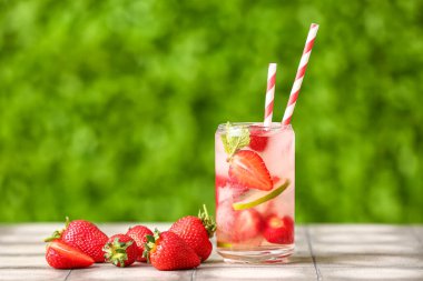 Dışarıdaki gri fayanslı masada çilekli limonata.