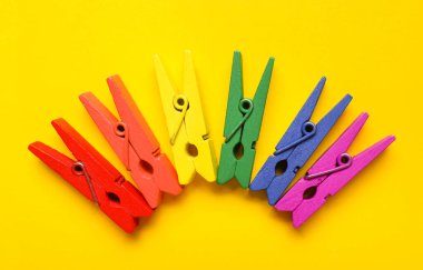 Sarı arka planda renkli mandallar. LGBT kavramı