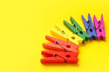 Sarı arka planda renkli mandallar. LGBT kavramı