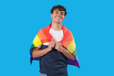 Mavi arka planda LGBT bayrağı olan genç adam