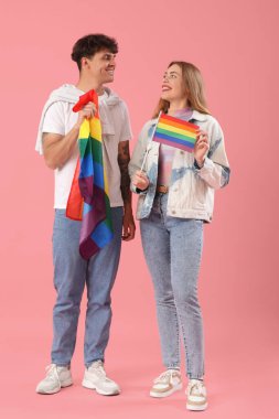 Pembe arka planda LGBT bayrakları olan genç bir çift